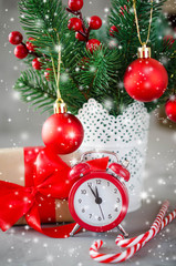 Fototapeta na wymiar Christmas composition: xmas fir branches, alarm clock, gift box and decorations.