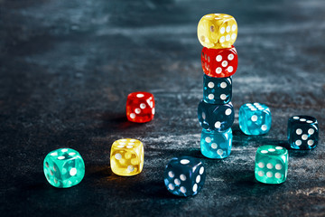 Colorful dice on a dark background, selective focus, color toned picture.