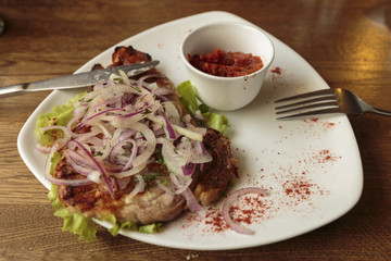 Pork barbecue with sauce adjika and onion rings.