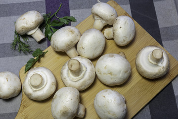 Fresh champignons on a cutting board, ready for cooking, vegan food.