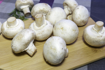 Fresh champignons on a cutting board, ready for cooking, vegan food.