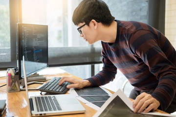 Pensive programmer working on on desktop pc programming code technologies or website design at...