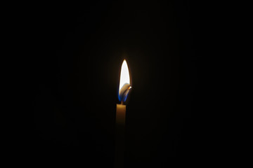 Flame of a candle, closeup, is isolated on black. Abstract Background.