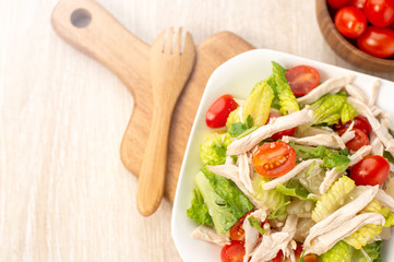 Fresh and delicious homemade chicken salad with tomatoes and pomelos in wooden background, concept of healthy and diet, top view, copy space