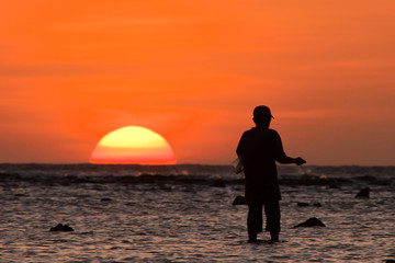 Philippines. Sunset. A man by the ocean.
