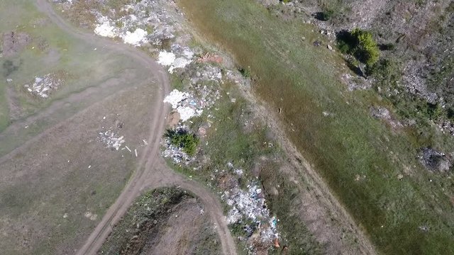  Flight over the dirt road, which has a lot of heaps with garbage. People throw construction garbage, household waste, polluting the environment.