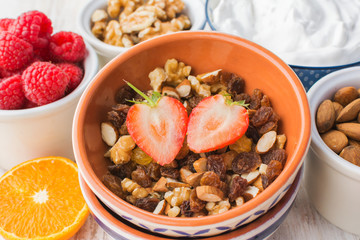 Healthy paleo gluten and grain free nut and fruit granola served with fruits and berries, nut milk, coconut yogurt, selective focus