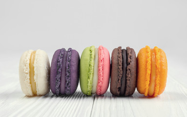 Colorful french macaroons on white wooden table