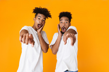 Two excited male african friends in t-shirts standing