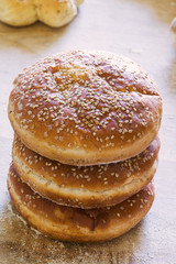 Three loafs with sesame seeds on wooden background.