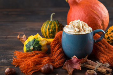 Pumpkin latte with spices and whipped cream on top on a wooden background. Copy space. Autumn or winter hot drink.