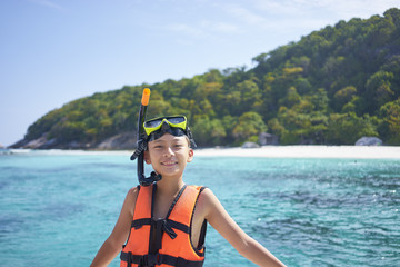 happy Asian boy wearing snorkel and preparing for swimming in Phuket, Thailand