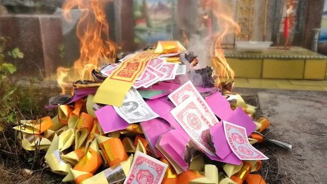 Chinese with taoism belief offers the deceased with burning of paper money and other offerings during qingming festival in Malaysia
