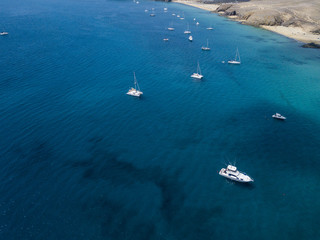 Vista aerea delle coste frastagliate e delle spiagge di Lanzarote, Spagna, Canarie. Strade e sentieri sterrati. Bagnanti in spiaggia. Oceano Atlantico. Papagayo