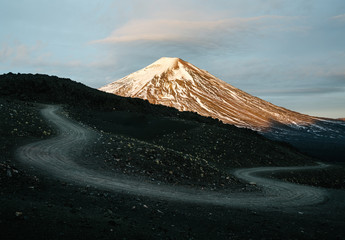 A dirt road switchback leads to Volcano Lonquimay at sunrise in the Andes of Chile
