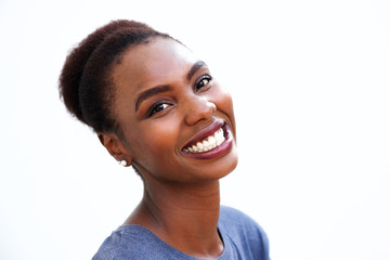 Close up smiling young black woman against isolated white background