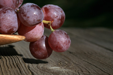 Bunch of grapes on a wooden table an old, country house. An element of outdoor decoration on the...