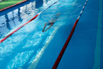 Image of sportsman swimming on path in pool