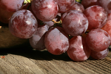 Bunch of grapes on a wooden table an old, country house. An element of outdoor decoration on the occasion of a harvest festival at the end of summer.