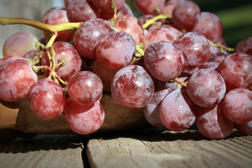 Bunch of grapes on a wooden table an old, country house. An element of outdoor decoration on the occasion of a harvest festival at the end of summer.
