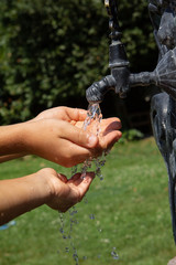 Pure water flowing into child's hands