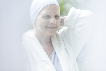 Flare of happy and smiling sick elderly woman with cancer
