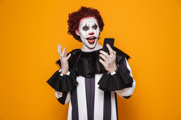 Surprised man clown using smartphone isolated