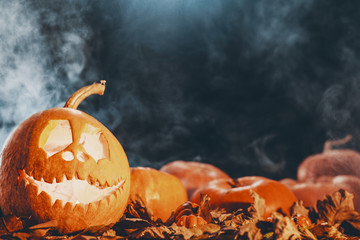 Image of a jack-o-lantern and pumpkins on a dark background, real photo with copy space