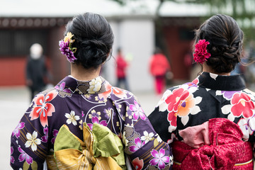 Young girl wearing Japanese kimono standing in front of Sensoji Temple in Tokyo, Japan. Kimono is a...