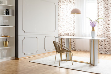 Real photo of a glamour dining room interior with a table, chair, flower and empty wall. Place your painting