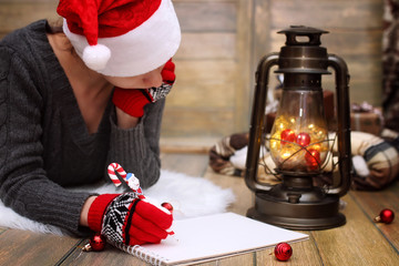girl writes pen on a piece of paper Christmas wishes