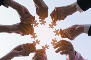 team hand placing the  jigsaw puzzle piece for connect business partner and connection solution  concept worker  unity team.