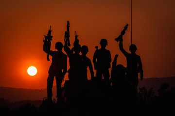 Fototapeta na wymiar twilight landscape silhouette military and holding gun
