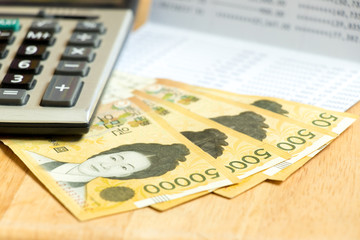 Bank book, calculator and south korea won (krw) banknote on wood table background