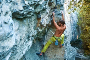 Deurstickers rock climbing. man rock climber climbing the challenging route on the limestone wall © vitaliymateha