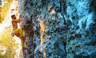 Rolgordijnen rock climbing. man rock climber climbing the challenging route on the limestone wall © vitaliymateha