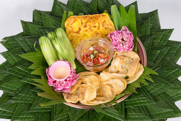 Fish Roti Mataba (filled roti) served with a sweet chili vinegar dip and cucumber salad in a white plate placed on wooden background. Thai Desserts