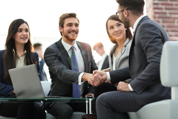 Two colleagues handshaking after meeting.