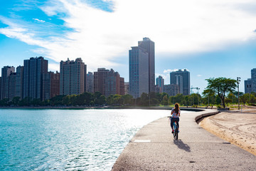 Woman Riding Bike Along Lake Michigan Towards the Sun in Chicago