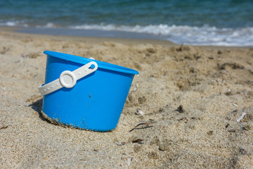 Children's beach toy on the beach - blue bucket . Close up view.