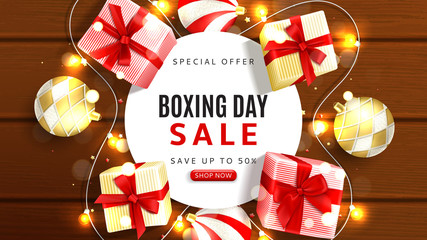 Web banner for Boxing day sale. Top view on realistic gift boxes, garlands and Christmas balls on rustic wooden texture. Vector illustration with confetti and effect bokeh.
