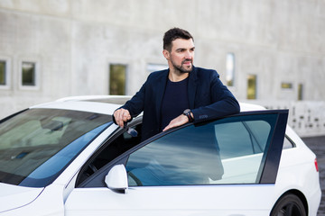 portrait of handsome man driver posing near his car