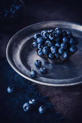 Blaubeer-Stillleben mit dunkelm Hintergrund