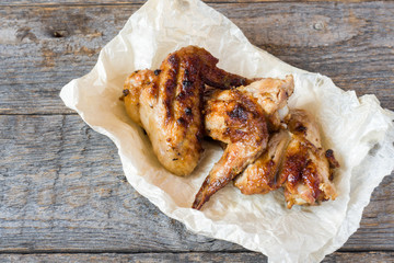 Chicken wings baked on grill on wooden background