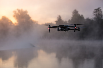 Drone copter with digital camera, river on background. Modern technology, UAV concept.