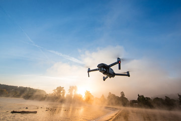 Drone copter with digital camera, river on background. Modern technology, UAV concept.