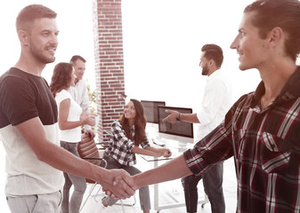 handshake colleagues in creative office