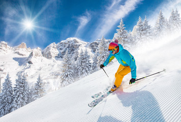 Skier skiing downhill in high mountains