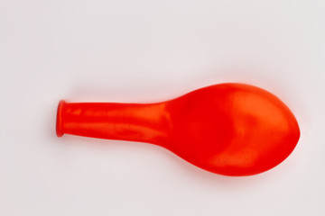 Red balloon without air. New colorful balloon isolated. Object for birthday party decor.