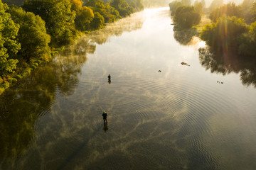 Photo aérienne d& 39 un homme pêchant à la mouche dans une rivière au cours d& 39 un matin d& 39 été.